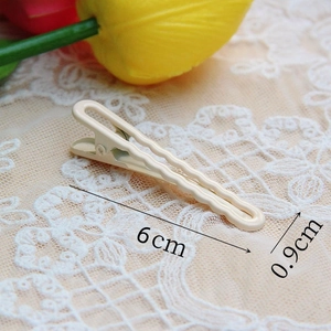 Detailed size view of a 6cm beige wavy metal hair clip on elegant lace background