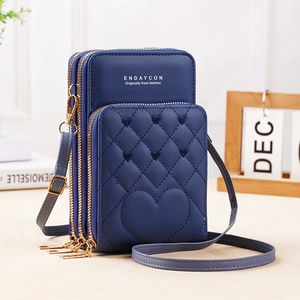 Detail of three-layer zipper design and heart quilted texture on blue crossbody phone bag