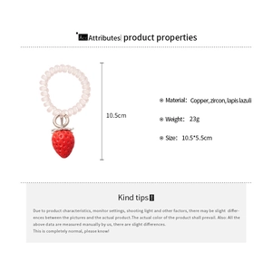 Détail d'un élastique spirale avec breloque fraise, dimensions 10,5x5,5 cm et poids 23 g