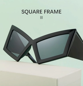 Detail view of black oversized cat eye sunglasses on a white pedestal, square frame design