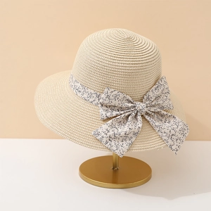 Chapeau de soleil en paille couleur avoine avec ruban floral sur un support élégant