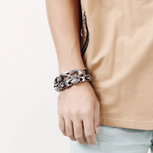 Detail of vintage silver titanium steel bracelets with cross and feather engravings