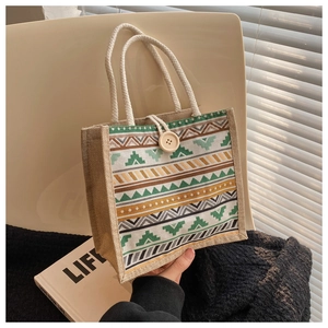 Détail du sac à lunch en lin avec motifs ethniques et fermeture bouton en bois rustique
