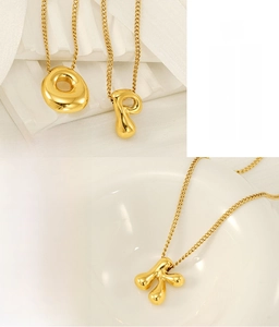 Detail of eco-friendly gold plated stainless steel letter charms with polished finish