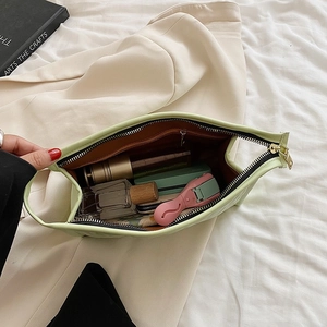 Green quilted vanity bag with makeup items inside showing spacious storage capacity