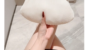 Detailed view of white pleated fabric texture on a soft bridal cloud clutch bag