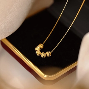 Gold necklace with six frosted geometric transfer beads on a delicate chain in a gift box