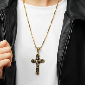 Detail of vintage gold religious cross pendant on box chain worn by male model