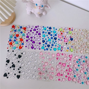 Detailed close-up of colorful 3D heart and round crystal diamond stickers for DIY crafts