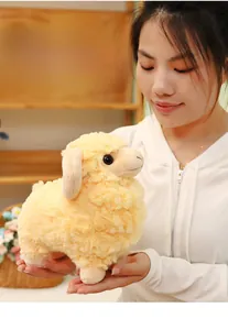 Detail of soft cream sheep plush toy showing fluffy texture and cute embroidered details