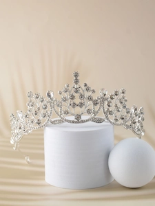 Detail of silver bridal crown with crystals on a pedestal with elegant soft shadows