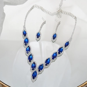 Close-up of silver bridal jewelry set with marquise-cut sapphire blue stones and white zircons