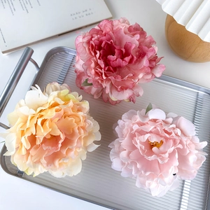 Detailed view of layered fabric peony hair claws in magenta, pink and orange colors