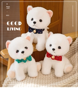 Three white Pomeranian plush puppies with colorful polka dot bows on a cozy knit blanket