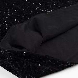 Close-up of black sequin embroidery fabric with soft inner lining on evening dress