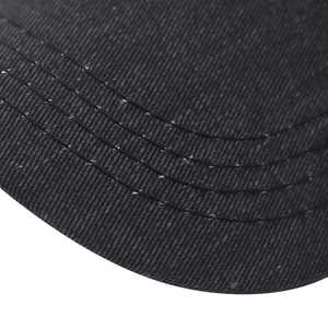Close-up of black cotton baseball cap brim featuring four parallel reinforcement seams