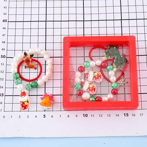 Christmas jewelry set with Santa and reindeer charms displayed on a measuring grid