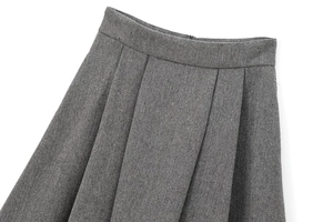 Detail of grey herringbone pleated mini skirt showing fabric texture and waistline