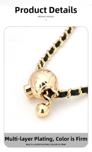 Macro shot of gold-plated metal chain woven with black leather and quilted ball detail