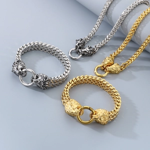 Detail of gold and silver stainless steel lion head necklaces and bracelets set on grey