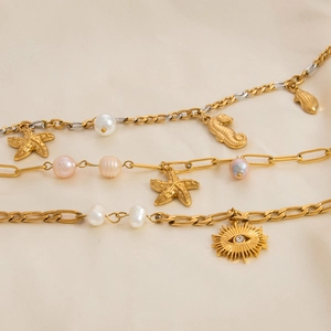 Gold stainless steel ocean bracelet featuring starfish, freshwater pearls and evil eye charms