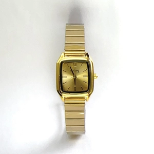 Detailed close-up of a golden square dial quartz watch with Roman numerals and metal strap