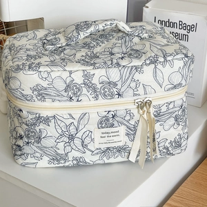 Quilted cotton toiletry bag with blue floral print and ribbon zipper detail