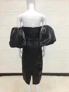 Detail of the oversized puff sleeves and back invisible zipper on this black satin dress