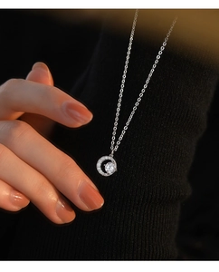 Detail of S999 silver moon necklace with zircon stones worn over a black sweater