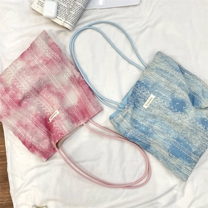Detailed shot of tie-dye lace shoulder bags in pink and blue with geometric patterns
