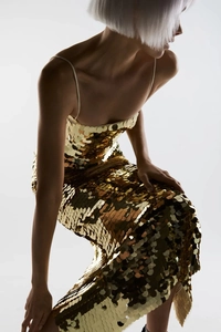 Detailed view of luxury gold sequins on a slim fit evening dress with thin straps