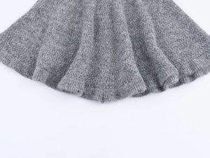 Détail de la maille grise ajourée avec ourlet à volants doux et motif de crochet