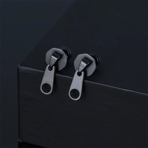 Macro shot of creative matte black zipper head earrings in a minimalist punk style