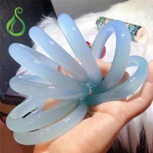 Close-up of sky blue translucent agate chalcedony bangles on white faux fur background