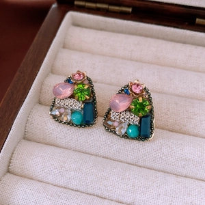 Gros plan de boucles d'oreilles triangles vintage avec cristaux multicolores dorés