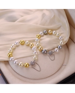Détail du bracelet en perles avec fermoir magnétique en zircone sur de la soie
