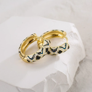 Vintage geometric enamel hoops in 18K gold plating on a textured stone surface