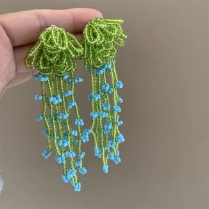 Handmade beaded flower earrings with green cluster and light blue long tassels