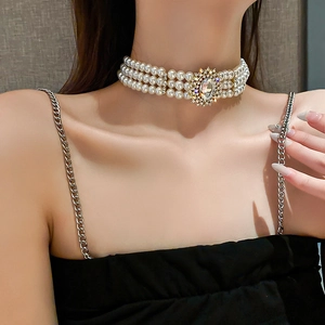 Close-up of triple-layer pearl choker with large oval rhinestone centerpiece and crystal accents