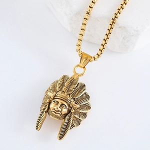 Detail view of a gold Indian chief head pendant on a box chain over white stone