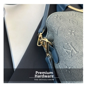 Close-up of golden hardware and monogram denim fabric on a bucket shoulder bag