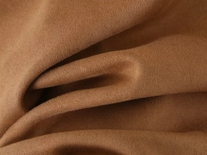 Macro view of camel faux suede fabric showing soft texture and natural pleats