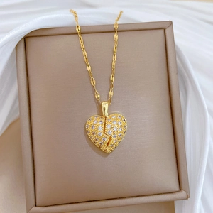 Close-up of a double-layer golden broken heart necklace featuring full pavé diamonds