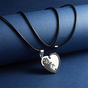 Detail of heart puzzle pendants with black and white cats on blue background