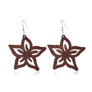 Detail of dark brown wooden hollow star earrings with silver hooks on white background