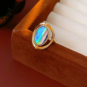 Close-up of a gold oval shell ring on a brown velvet jewelry box for a vintage look