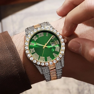 Close-up of luxury hip hop watch with green Roman dial and rhinestone bezel on wrist