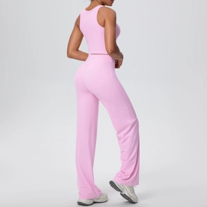 Dettaglio laterale di un set yoga rosa con pantaloni a zampa e top corto sportivo