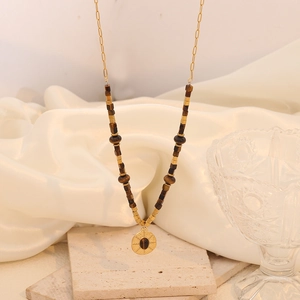 Detail of double-layer stainless steel necklace with tiger stone beads and heart pendant
