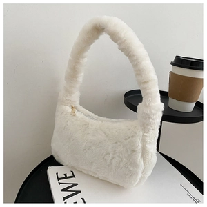 Détail de la texture d'un sac à main en fausse fourrure blanche avec fermeture dorée